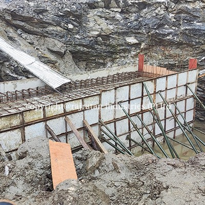 Masonry crew cutting, nailing, and drilling durable PAC plastic shuttering boards during formwork training on a construction site